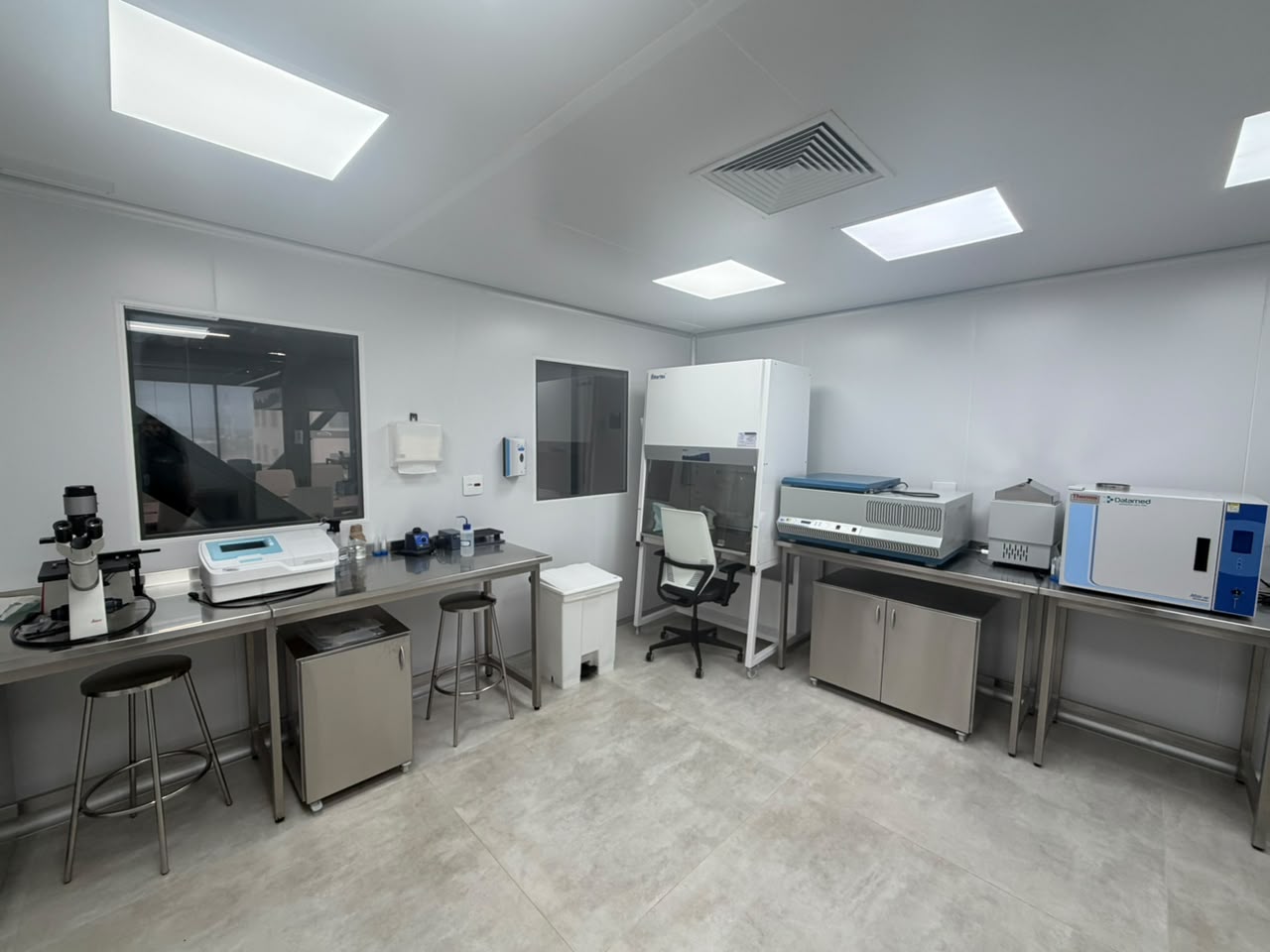 Sala limpa do Instituto Nupen com capela de fluxo laminar, microscópio e equipamentos de análise