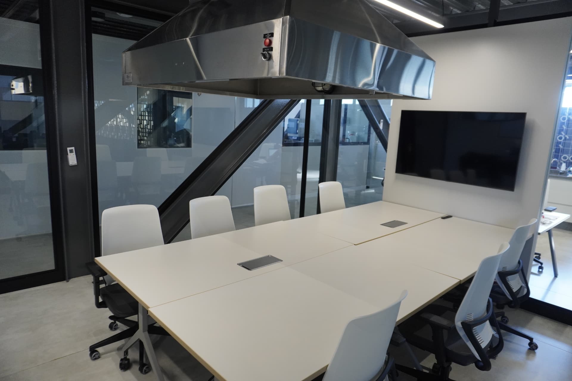 Sala de treinamento do Instituto Nupen com mesa ampla, cadeiras e monitor de apresentação